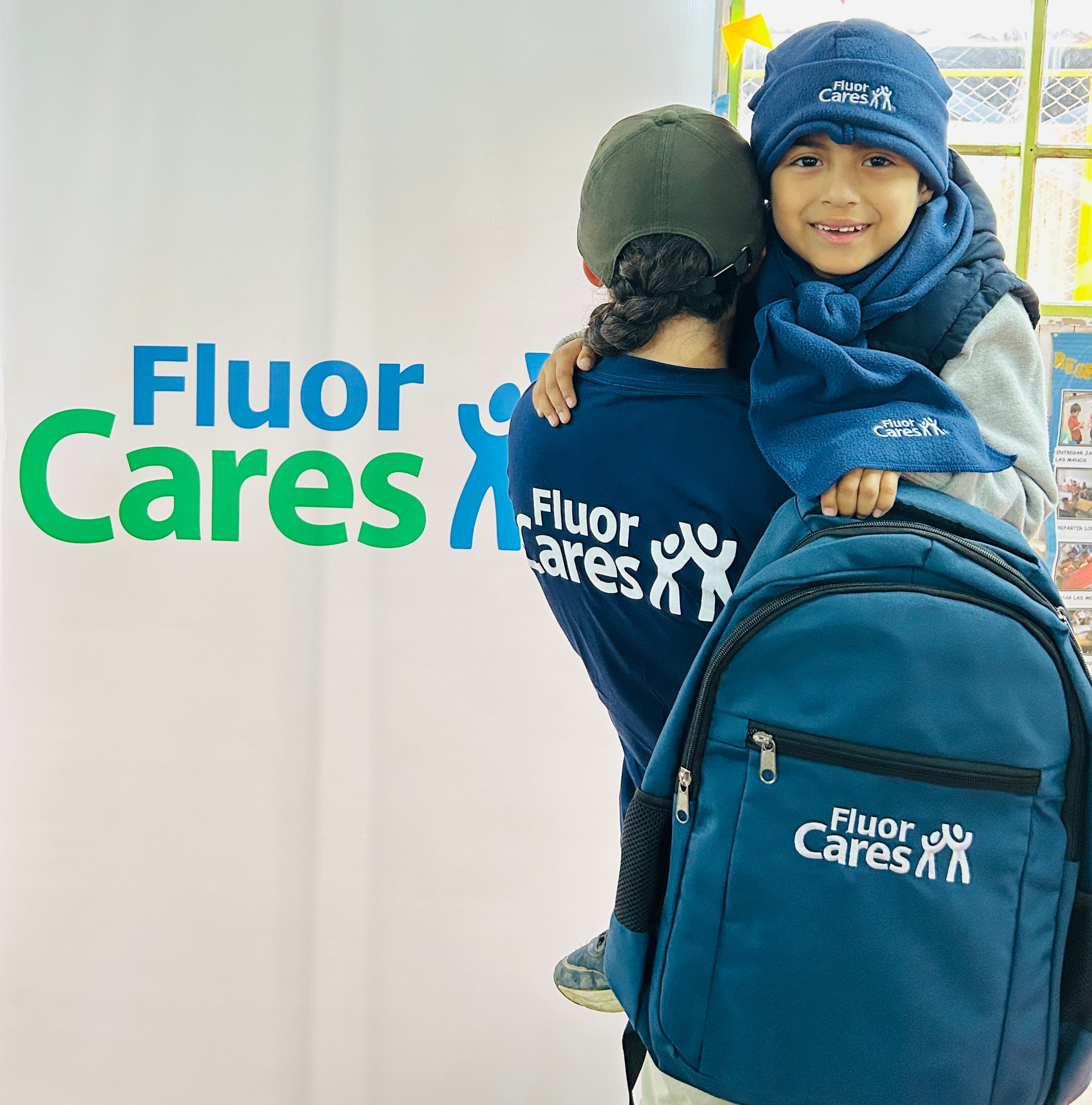 Woman with child  holding backpack full of donated school supplies